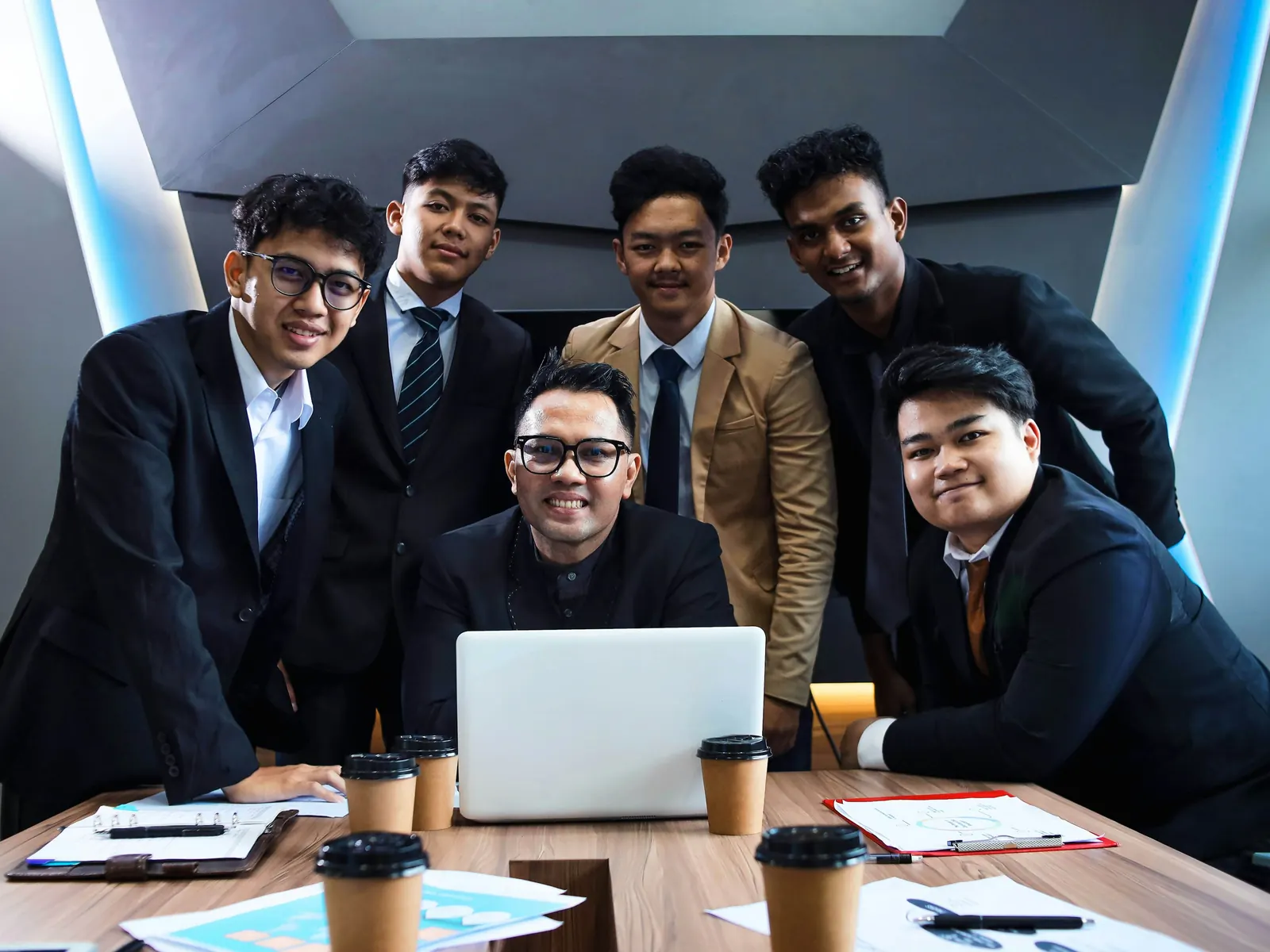 Team of young professionals gathered around a laptop