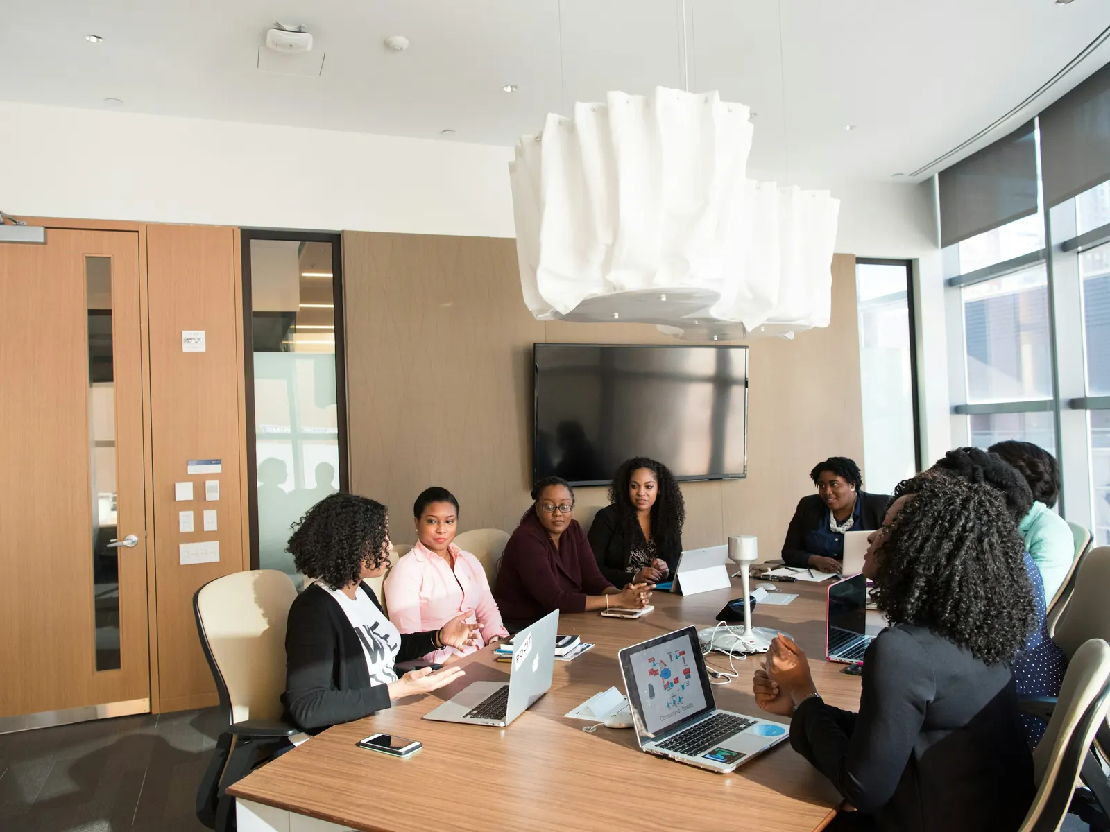 Team meeting with laptops around a table in a bright conference room