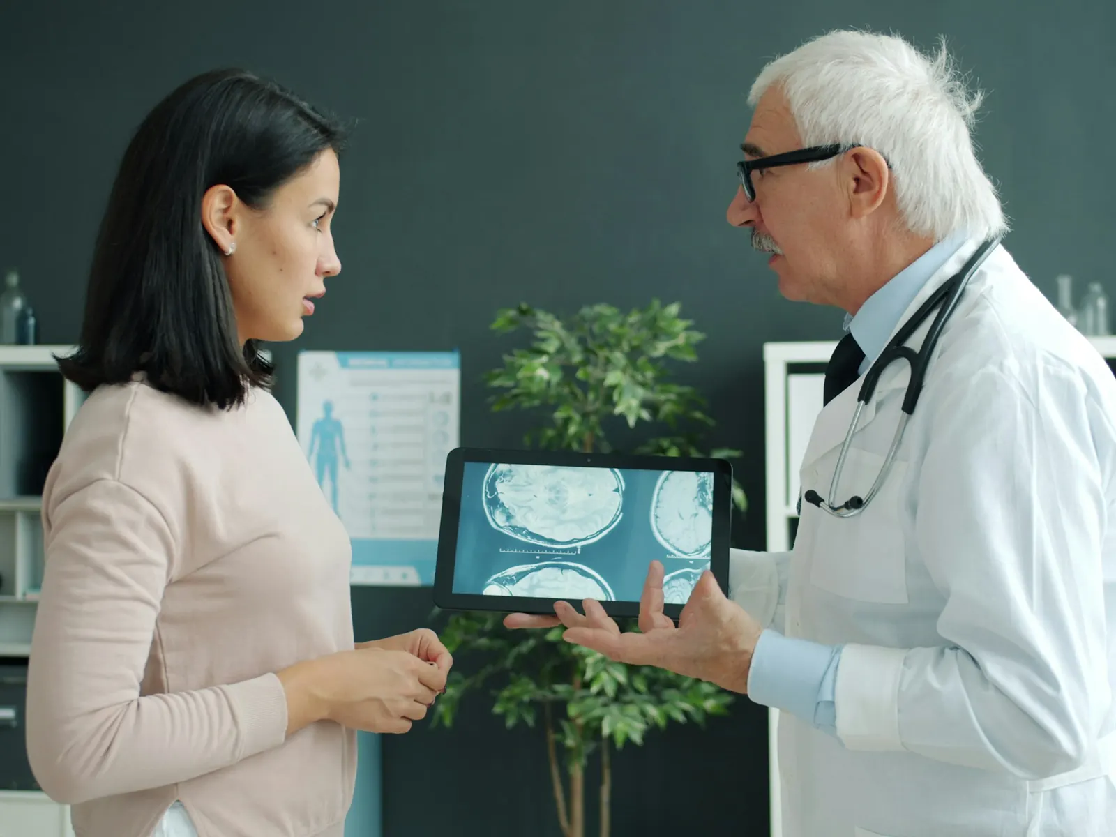 Doctor walking a patient through medical scans on a tablet